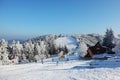 Snow-covered slope, lift cableway and a lot of skiers