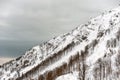 Snow-covered slope of the mountain on a cloudy day