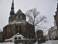 Snow covered St. Peter`s Church in Riga, Latvia. The red brick church with a Gothic tower in the old town is one of the symbols o Royalty Free Stock Photo