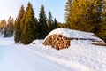 Snow covered stack of logs along a forest road in the mountains in winter Royalty Free Stock Photo