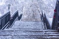 Snow covered staircase in winter, up from the river. soft focus. A metal staircase in a park covered by snow