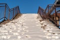 Snow covered stairs with stainless steel banister Royalty Free Stock Photo