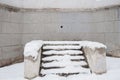 Snow-covered stone staircase near wall of old grey building with Royalty Free Stock Photo