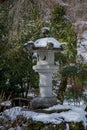 the snow is on top of this stone statue in the garden