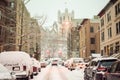 Snow-covered street and cars on a cold and dreary winter`s day in Harlem, New York, NY, USA