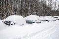 Snow-covered street road and cars under the snow. Heavy snowstorm, blizzard traffic. Climate weather disaster. Winter urban scene Royalty Free Stock Photo