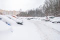 Snow-covered street road and cars under the snow. Heavy snowstorm, blizzard traffic. Climate weather disaster. Winter urban scene