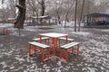 Snow covered table and benches in empty public cafe Royalty Free Stock Photo