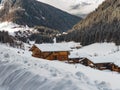 Snow covered traditional wooden mountain huts on cold Winter day