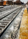 Snow-covered train tracks passes through suburban intersection. Royalty Free Stock Photo