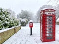 Snow covered village post box and phone box Royalty Free Stock Photo