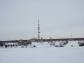 Snow-covered winding road leads to the radio tower with cellular phone in winter, near the village in the north of the Arctic Royalty Free Stock Photo