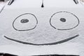 Snow covered windshield with drawn smile face Royalty Free Stock Photo