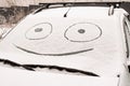 Snow covered windshield with drawn smile face Royalty Free Stock Photo