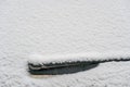 Snow covered rear windshield with wiper blades. Frozen snow on car in cold winter morning. Concept of driving in winter Royalty Free Stock Photo