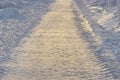 Snow-covered winter road illuminated by the setting sun Royalty Free Stock Photo