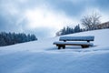 Snow-covered wooden bench in the idyllic winterlandscape in the mountains Royalty Free Stock Photo