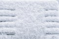 Snow covered wooden bench in winter park on fluffy white snow background Royalty Free Stock Photo