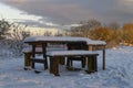 Snow covered wooden benches and Picnic Table along the River Bank in The Lurgies area of Montrose Royalty Free Stock Photo