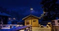 Snow covered wooden chalet in a white winter as The Milky way galaxy with star in the night -Alps, Switzerland Royalty Free Stock Photo