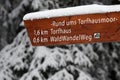 Snow covered wooden directional signpost with labeling