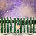 Snow-covered wooden fence with paper heart Royalty Free Stock Photo