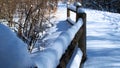 A snow covered wooden fence and trail in a Northern Illinois, USA, forest preserve Royalty Free Stock Photo