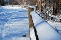 A snow covered wooden fence and trail in a Northern Illinois, USA, forest preserve Royalty Free Stock Photo