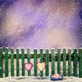 Snow-covered wooden fence with two paper hearts Royalty Free Stock Photo