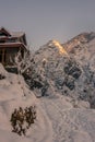 Snow covered wooden house in mountains - Majestic winter landscape in himalayas