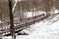 Snow-covered wooden pedestrian bridge in the winter forest Royalty Free Stock Photo