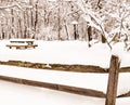 A snow covered wooden picnic table and wooden fence in a field in Frick Park in Pittsburgh, Pennsylvania, USA Royalty Free Stock Photo