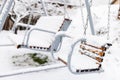 Snow covered wooden white swing after heavy snow. Winter frosty day Royalty Free Stock Photo