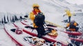 Snow falling as kayakers prepare their gear in Antarctica.