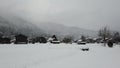 Snow falling in small town that has been covered by snow