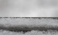 The snow falls on the windowsill. Close-up