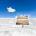 Snow field and blue sky with wooden sign board. Royalty Free Stock Photo