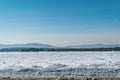 Snow field, forest and mountains against blue sky Royalty Free Stock Photo