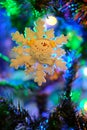 Snow flake ornament on a nicely illuminated Christmas tree