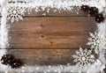 Snow frame with snowflakes and cones over wooden background, copy space Royalty Free Stock Photo