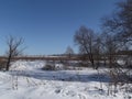 Snow on a frozen pond is covered by blue shadows Royalty Free Stock Photo