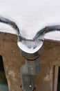 Snow and frozen water blocked the drain on the roof of the old house Royalty Free Stock Photo