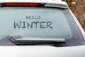 Snow on frozen window of parking white car in winter