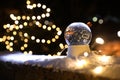 Snow globe and blurred Christmas lights on background Royalty Free Stock Photo