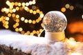 Snow globe and blurred Christmas lights on background Royalty Free Stock Photo