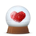 Snow globe with heart symbol on wooden stand