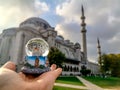 Snow globe with Istanbul in hand on a blurred background of the Suleymaniye Mosque. Souvenir from the Turkish tourist city, close- Royalty Free Stock Photo