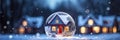 Snow globe with tiny modern house inside near big real cozy house with lights in windows in winter. Gift dream for Christmas, New
