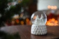 Snow globe on wooden table against blurred background. Bokeh effect Royalty Free Stock Photo