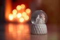 Snow globe on wooden table against blurred background. Bokeh effect Royalty Free Stock Photo